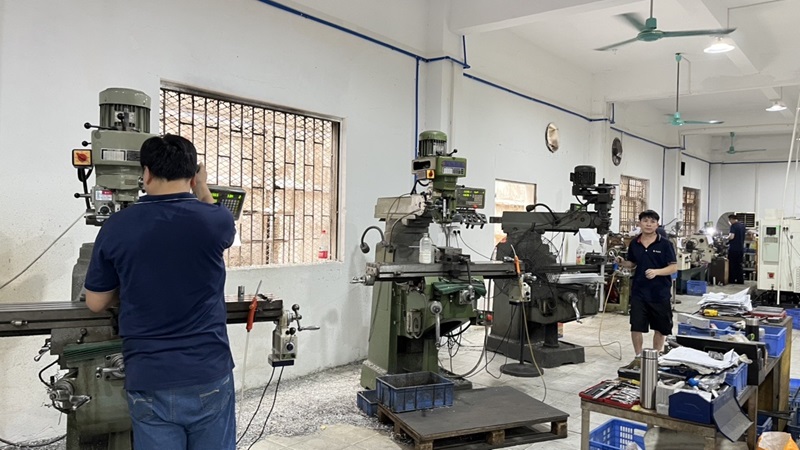 Taller de ensamblaje Amp Machine - Ingenieros trabajando en equipos cosméticos de precisión