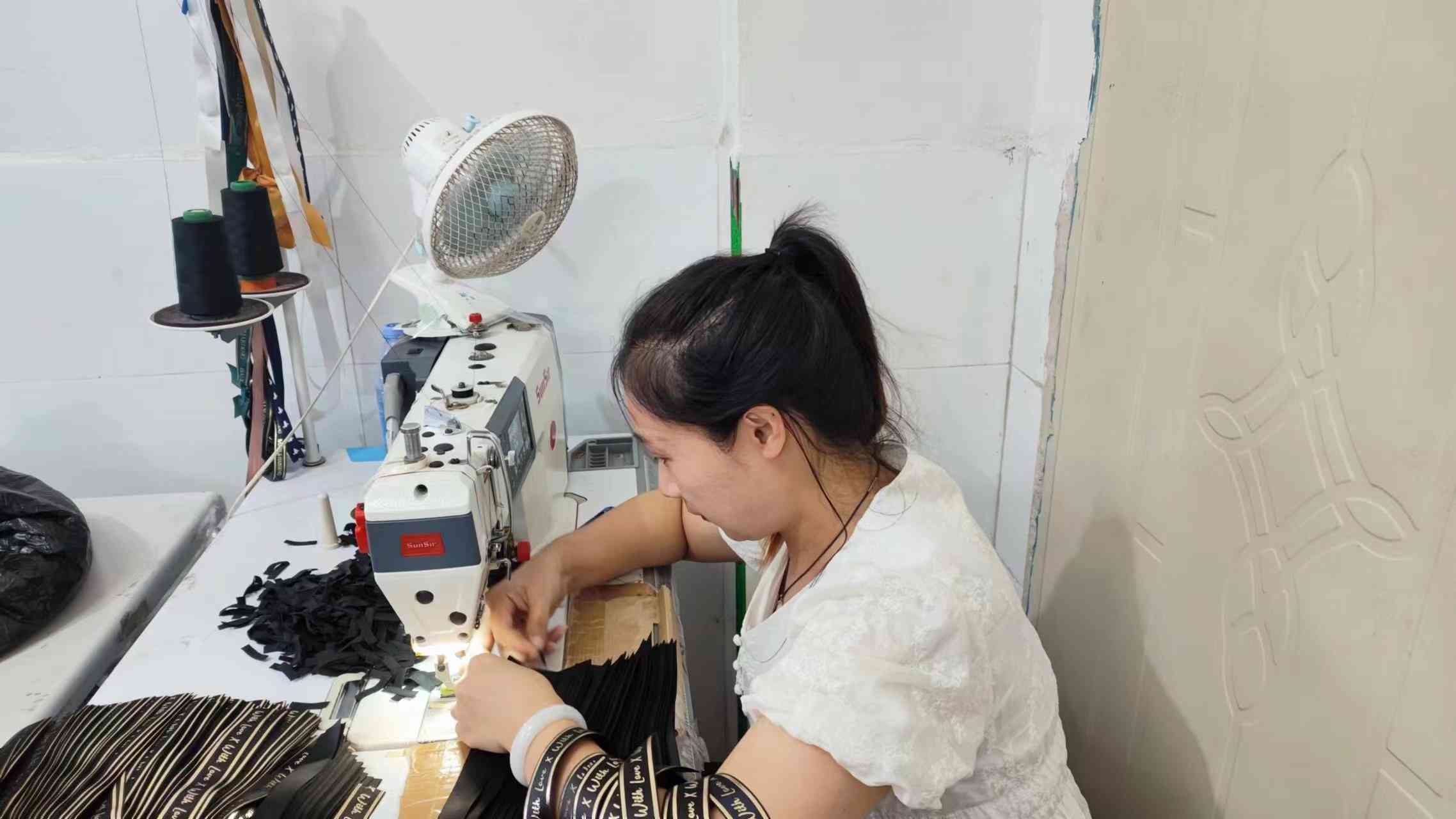 Sewing paper flower components together — skilled craftsman at Arden Decor factory