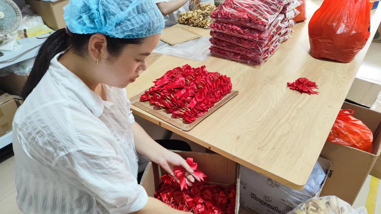 Final quality inspection of paper flower decorations before shipping at Arden Decor