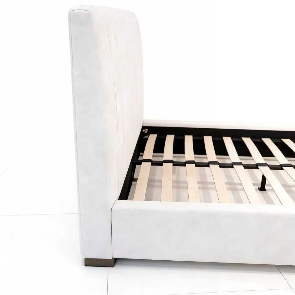 Estructura de cama tipo trineo tapizada con cabecera y pie de cama acolchados curvados, incluyendo base de listones de madera para soporte