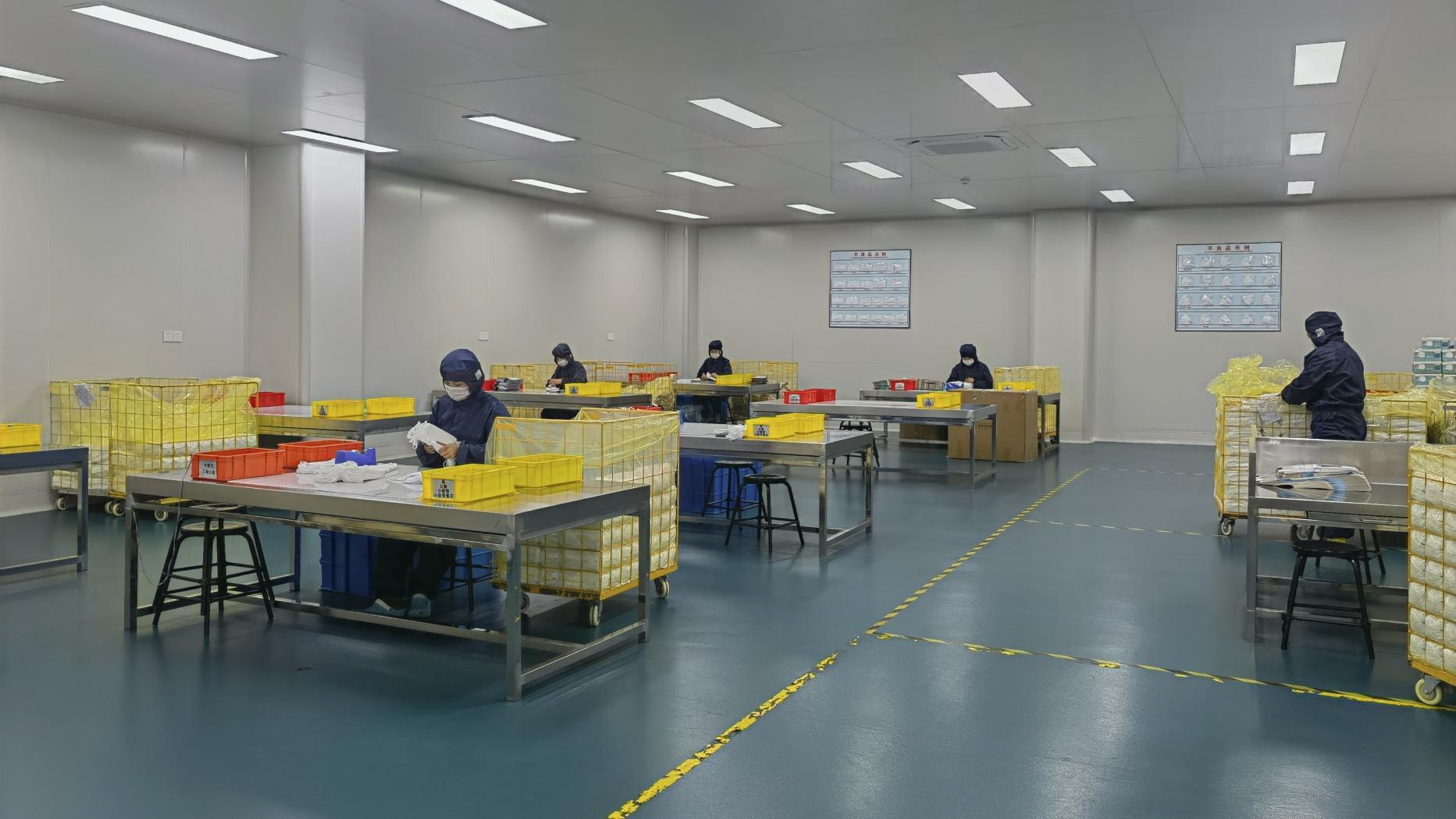 Detailed inspection and manual sorting of disposable masks in sanitised zone