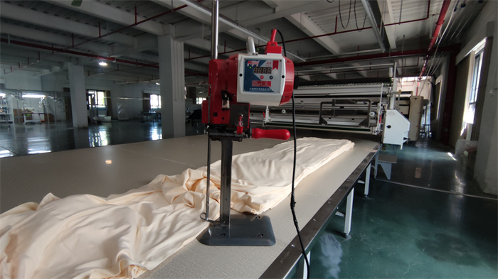 Electric shearing machine for precise fabric cutting at Eglin Fashion factory