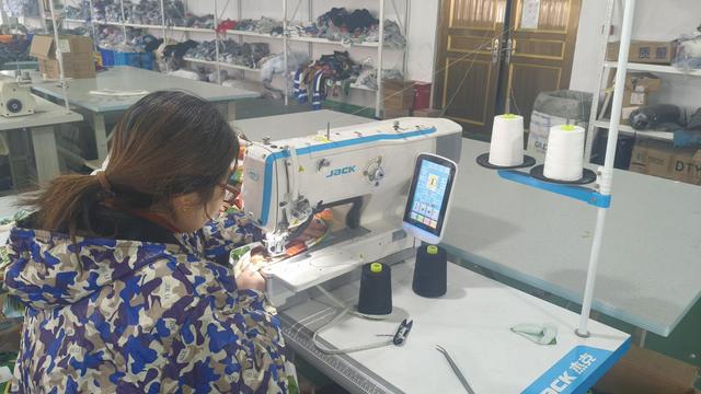 Workers conducting final garment finishing, pressing, and sorting.