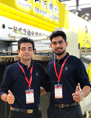 Customers inspecting SHANHE post-press equipment at exhibition