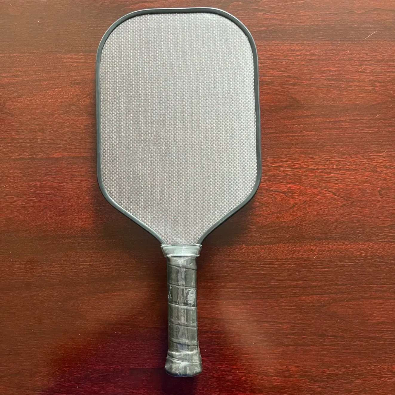 Paleta de pickleball compuesta de fibra de carbono con núcleo de panal y mango ergonómico para competiciones profesionales de pickleball
