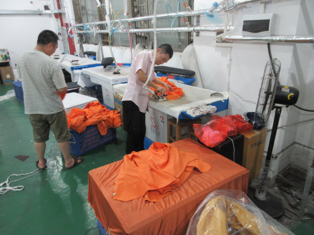 Steam ironing and finishing of garments at Jedia Clothing production line