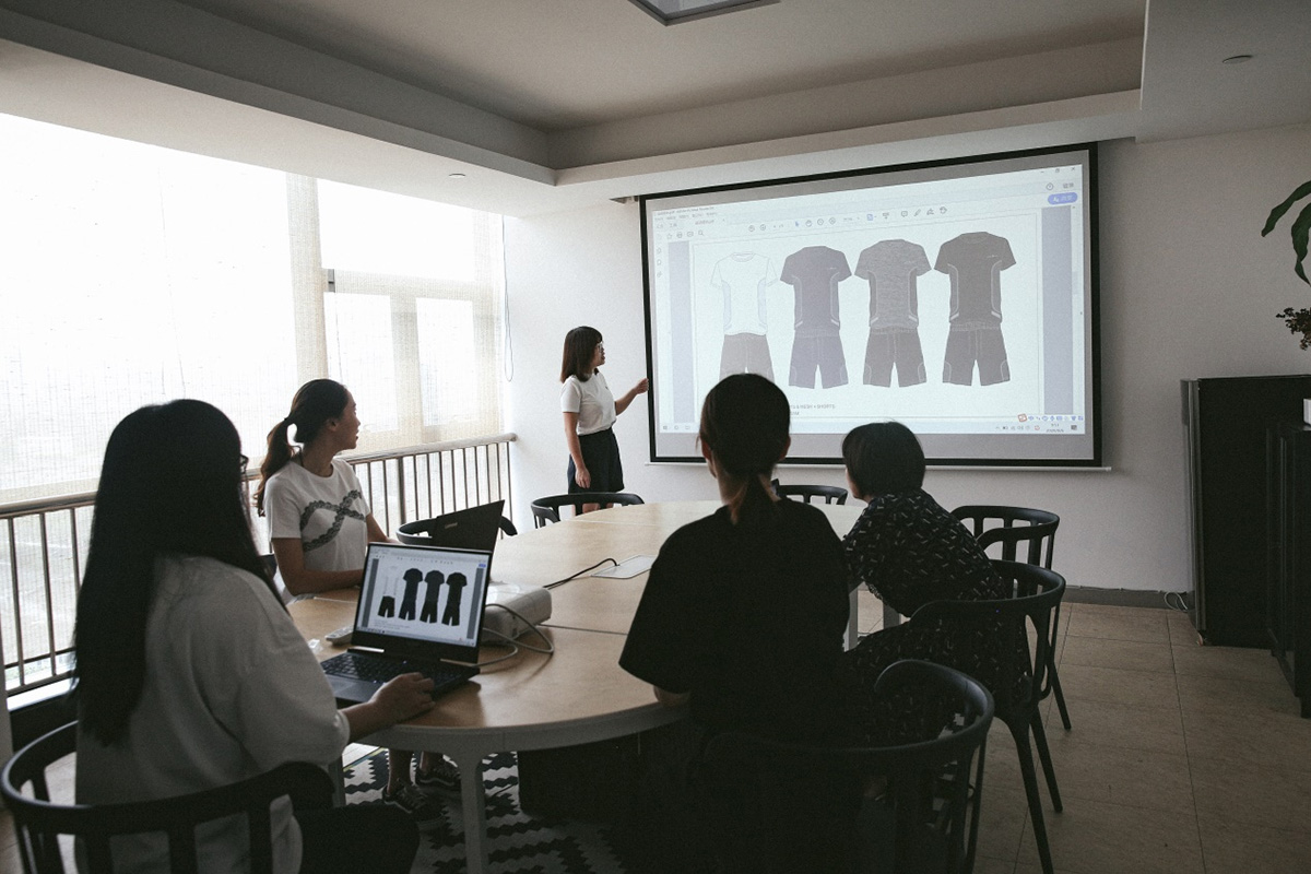 Jinmao professional garment design team working on fashion sketches and fabric selection