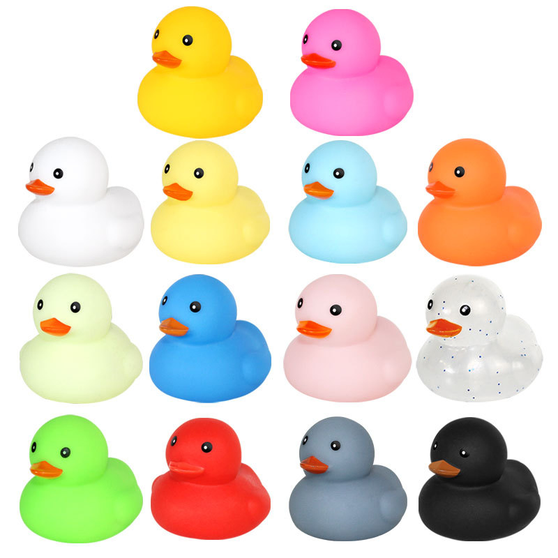 O pequeno pato de brinquedo do bebê toma banho e brinca na água. O pato amarelo de brinquedo aperta e grita