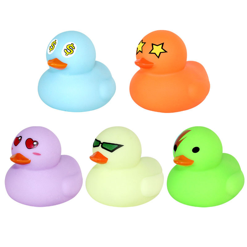 O pequeno pato de brinquedo do bebê toma banho e brinca na água. O pato amarelo de brinquedo aperta e grita