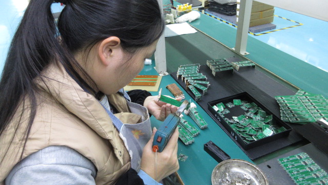 Manual soldering precision work at Nittanya Auto electronics quality control station