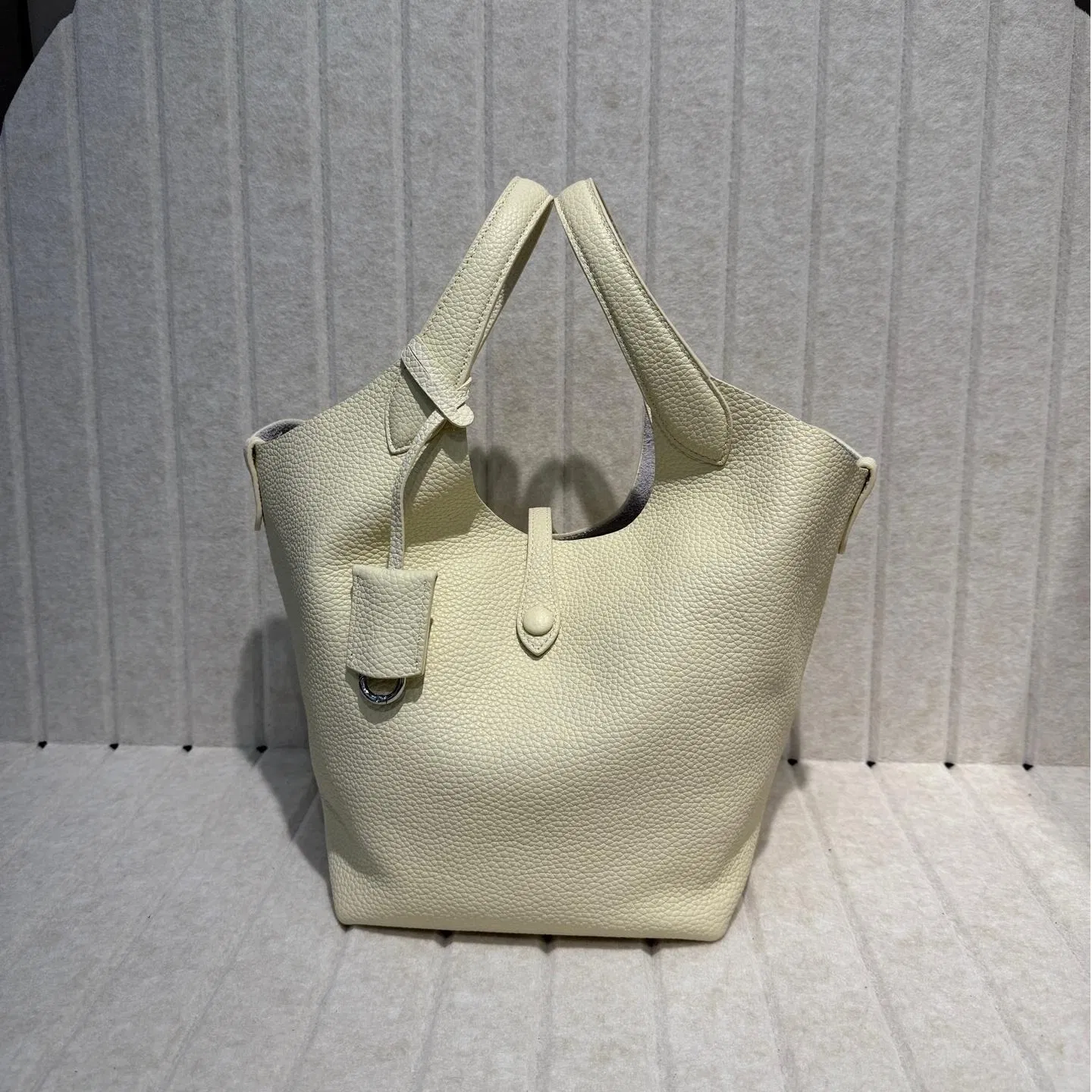 2025 Nueva bolsa de cesta de verduras de piel de vaca con grano de lichi, versión coreana del estilo minimalista, bolso casual tipo cubo para mujeres