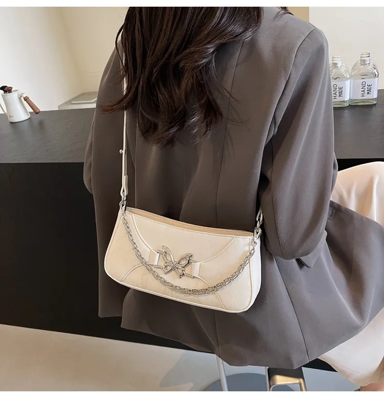 Bolso baguette de cuero blanco texturizado para mujer con decoración de mariposa plateada, bolso de cuero blanco casual con herrajes de mariposa y cadena