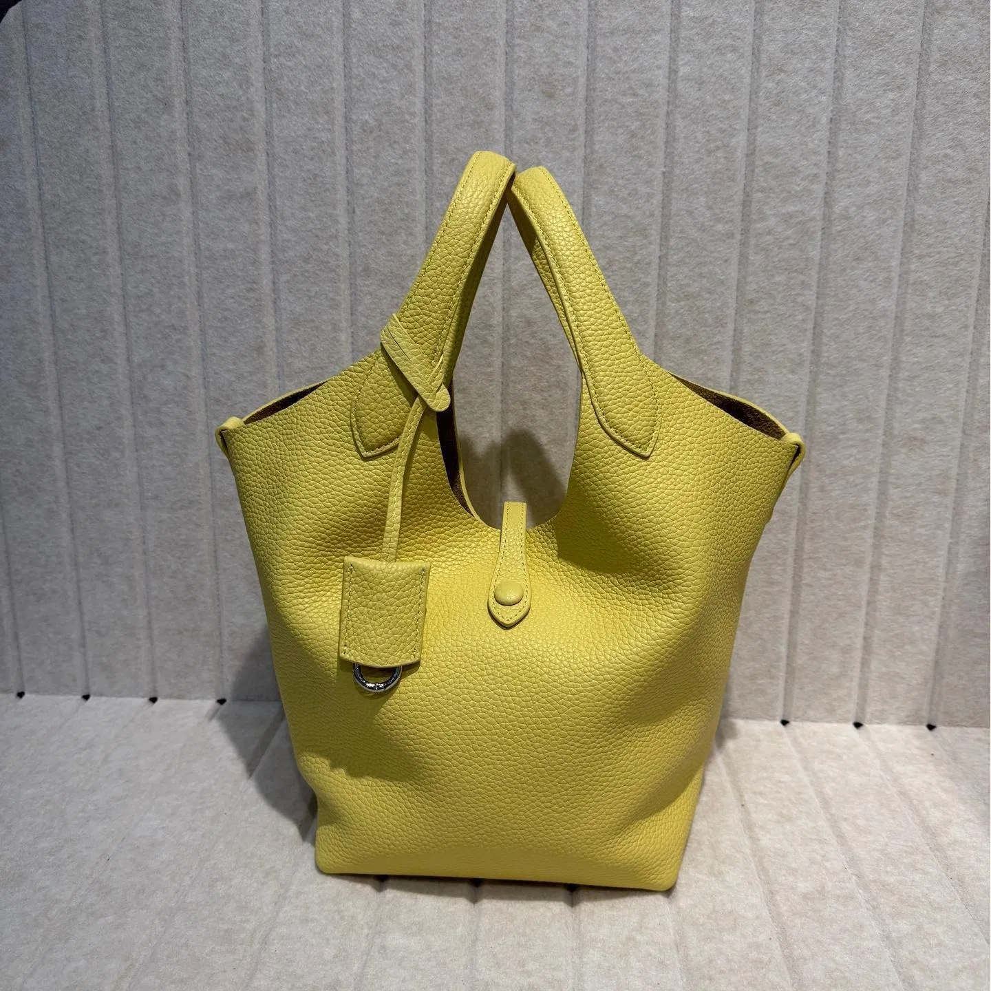 2025 Nueva bolsa de cesta de verduras de piel de vaca con grano de lichi, versión coreana del estilo minimalista, bolso casual tipo cubo para mujeres