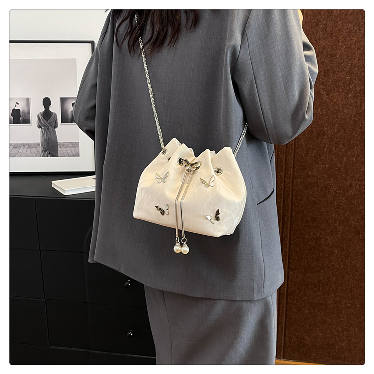Bolso de hombro de cuero PU para mujeres al por mayor con elegante charm de mariposa, bolso tipo cubo