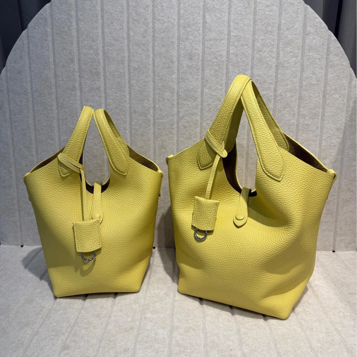 2025 Nueva bolsa de cesta de verduras de piel de vaca con grano de lichi, versión coreana del estilo minimalista, bolso casual tipo cubo para mujeres