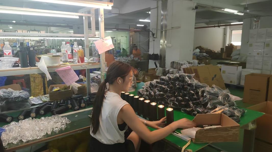 Quality inspection station at Pina Light — QC engineers testing LED luminaires for electrical safety