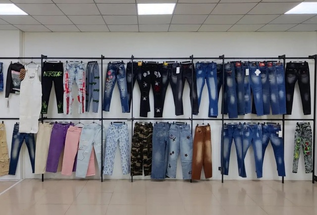Amostras de tecidos denim e vestuários de jeans acabados no showroom de design da fábrica