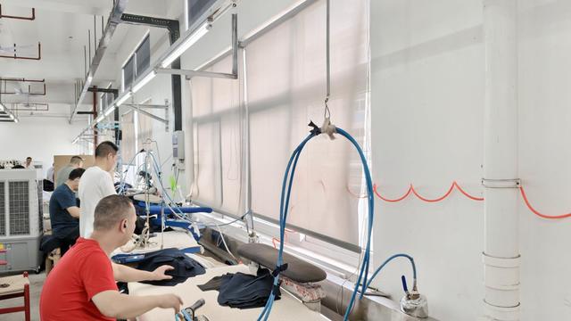 Technicians inspecting fabric grain alignment and structural seams