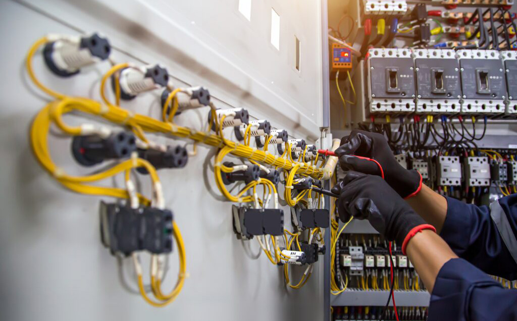 Electrician crimping wire connectors in an electrical distribution panel
