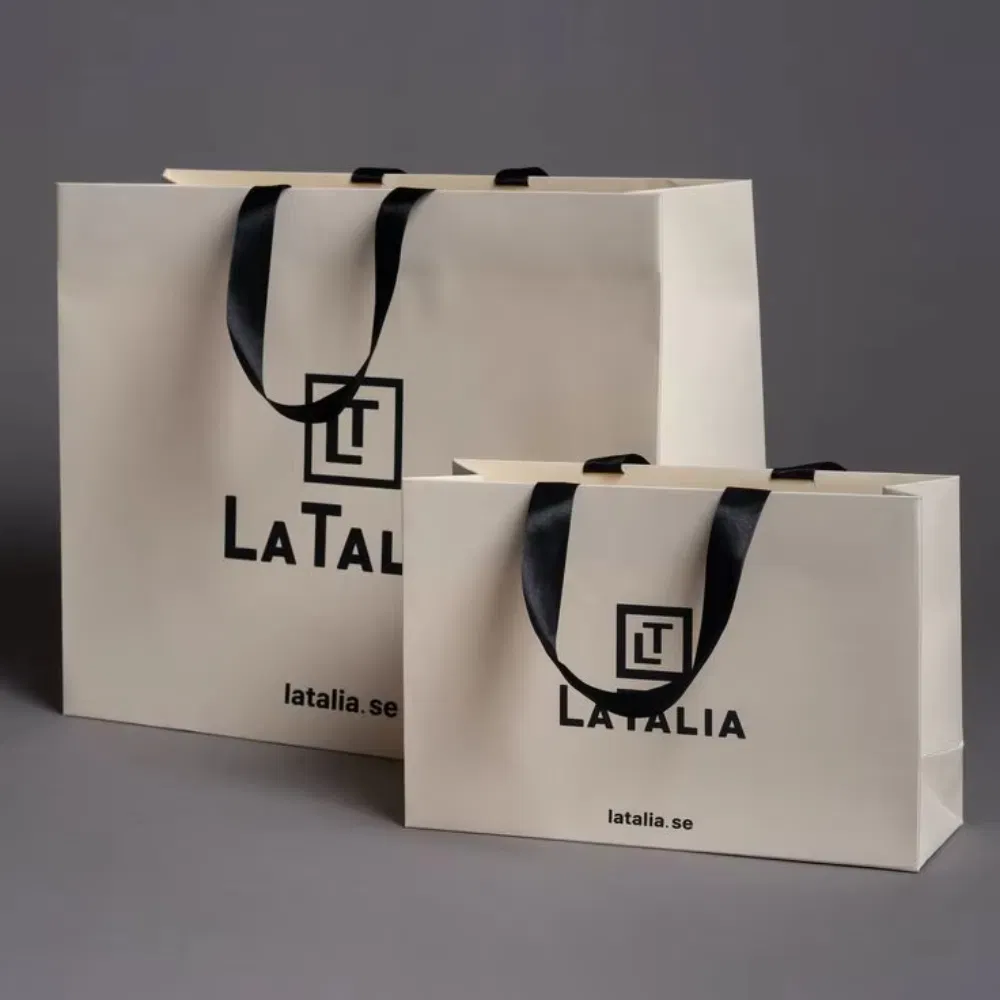 Bolsa de papel blanca personalizada con logo para regalo, con asas de cinta, para ropa de marca de lujo al por mayor para pequeñas empresas