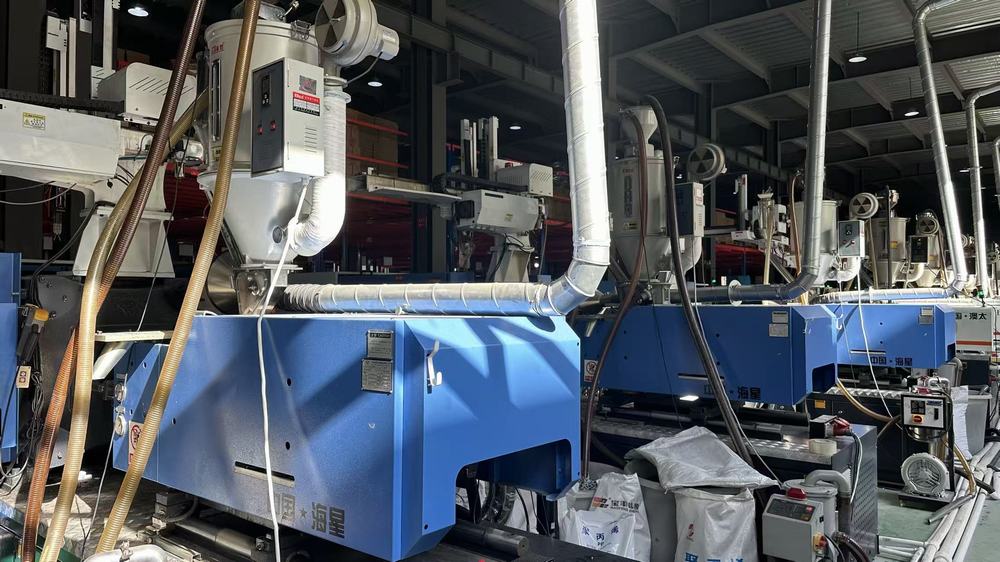 Injection molding machine manufacturing plastic components for storage organizers