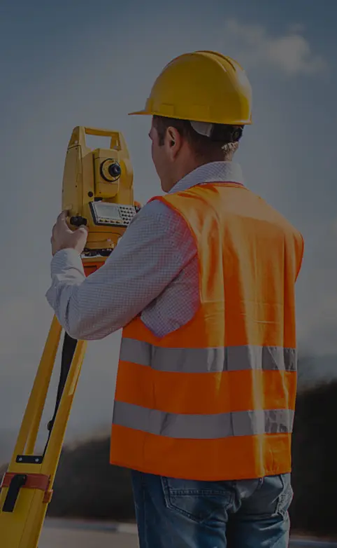 Surveyor wearing a high visibility reflective vest on site